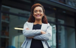 Mulher em pé com expressão vitoriosa mostrando engajamento de colaboradores
