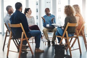 Grupo de seis pessoas sentadas em roda conversam