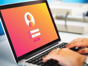 Pessoa acessa tela de login e senha de portal do colaborador no laptop