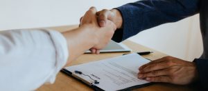 Aperto de mãos e uma mesa de trabalho abaixo