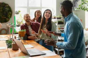 Quatro pessoas sorridentes em sala de reunião falado sobre o que é integração no trabalho 