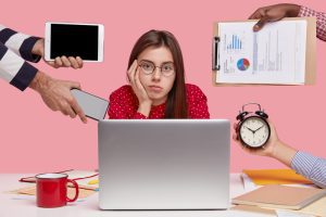 Mulher sentada em frente ao computador com expressão apática 