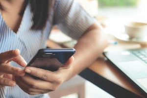 Plano fechado de braços femininos segurando celular 
