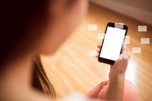 Mulher observa tela de celular com ilustrações de lembretes