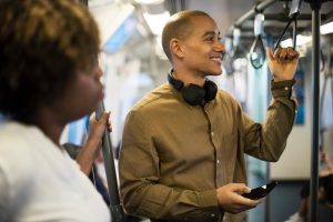 homem sorri no metrô utilizando seu vale transporte