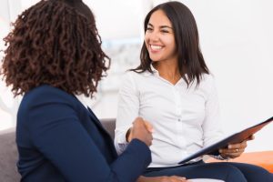 duas mulheres dão as mãos após acordo financeiro depois de rescisão