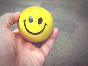 Uma mão segura um emoji smile como resultado do day off