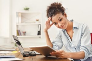 Mulher visualiza tela de tablet e faz expressão de erro ao fazer a provisão de férias