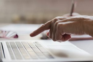 Homem aponta o dedo para o teclado do computador, autorizando a sua máquina para acessar a conectividade social