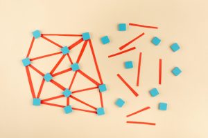 Uma imagem de pequenos quadrados ligados por linhas simboliza a resolução de problemas complexos que o design thinking ajuda a resolver