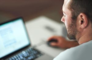 Homem acessa site da conectividade social em seu computador