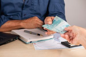 Homem recebe pagamento por realização de serviço e terá de emitir um recibo de pagamento para seu contratante