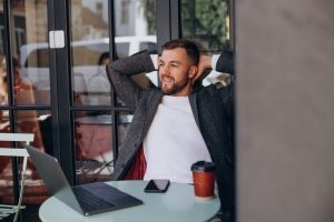 Profissional que pratica work-life balance relaxado trabalha de uma cafeteria
