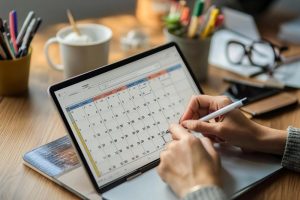 gestor de rh olha calendário para fazer provisão de férias de funcionários