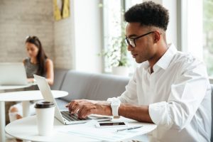 Jovem sentado em coworking cria indicadores de recrutamento e seleção