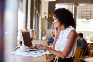 Mulher trabalha animadamente e sentindo-se valorizada por fazer treinamento online