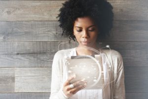  Mulher olha para o tablet e ao redor do gadget há diversos ícones em 3D que simbolizam o futuro do recrutamento inteligente
