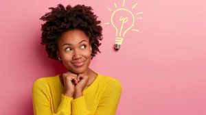Colaboradora sorridente olha para ilustração de lâmpada, sugerindo dicas para recrutamento misto