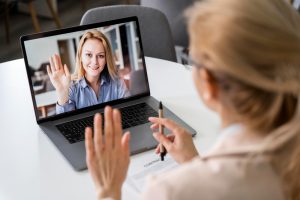 Mulher faz perguntas para entrevista de emprego via videoconferência para uma candidata
