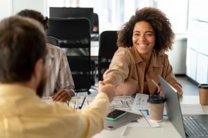 Candidata aperta mão de executivo em sala de reuniões de um ambiente profissional ao fazer inbound recruiting
