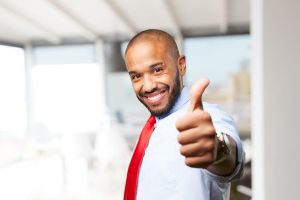 Jovem em pé acena positivamente por estar animado com o processo seletivo baseado no banco de talentos da empresa