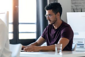 Profissional de RH trabalha no computador atualizando regularmente o banco de talentos da empresa