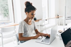 Mulher trabalhando no escritório cria no notebook um funil de recrutamento para sua empresa