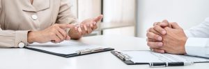 Pessoas à mesa com pranchetas analisam teste de integridade de candidatos à vaga de emprego