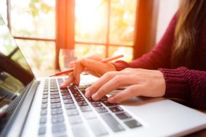  Detalhe de mulher acessando o FGTS Digital 2024 de seu notebook
