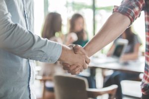 Dois homens apertam as mãos, simbolizando as possibilidades de negociação de uma convenção coletiva de trabalho