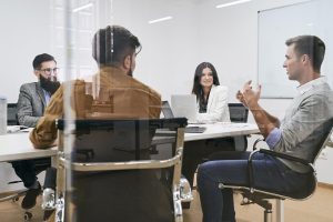 Colaboradores fazem reunião de trabalho presencial na empresa a portas fechadas