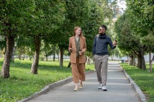 Dois jovens profissionais caminhando em um parque praticando ócio criativo