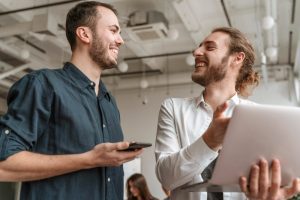 Colegas de trabalho conversam amigavelmente praticando boas relações laborais