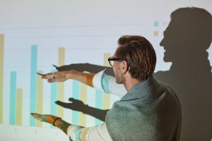 um homem trabalhador mostrando um gráfico digital de comunicação corporativa