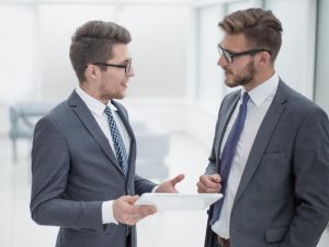 um funcionário do RH e um colaborador da escala 12x36 conversando com papéis na mão