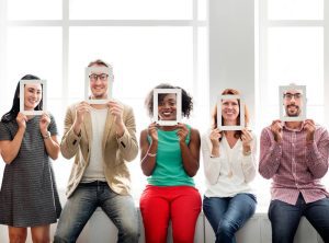 Cinco pessoas segurando molduras no rosto identificando o comunicador como um dos perfis comportamentais