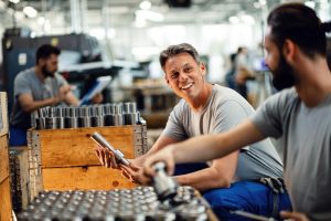 Homens trabalham animadamente, mantendo a assiduidade no trabalho