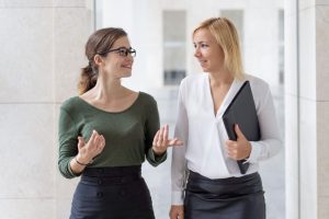 Duas colegas conversando amigavelmente praticando o que é ética profissional