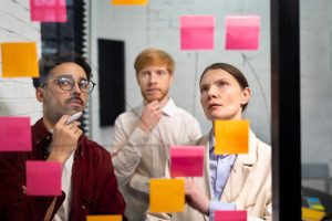 Grupo de colaboradores analisa post-its enquanto fazem diagnóstico organizacional