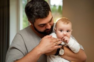 Homem cuida de filho em licença parental