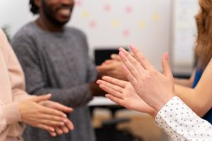 Closes em mãos de pessoas sendo aplaudidas por demonstrarem competências socioemocionais