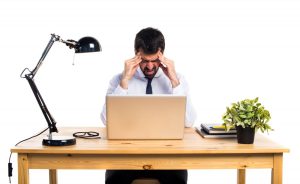 Homem com expressão sobrecarregada demonstra falta de bem-estar no trabalho?