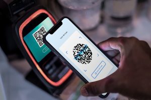 pessoa faz pagamento por aproximação via qr code