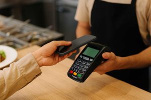 pessoa paga conta de restaurante mostrando como funciona o cartão benefício combinado