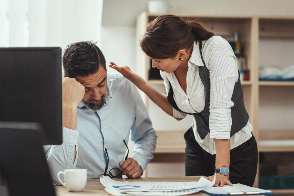 dupla de gestores reunidos em uma mesa de escritório discutem o problema das férias vencidas dos funcionários