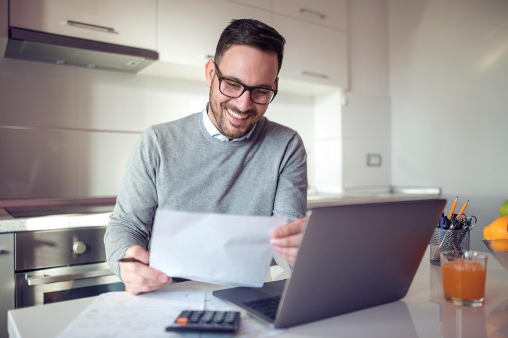 homem analisa com expressão feliz o seu holerite