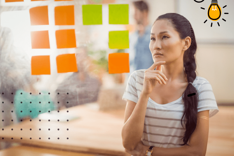 mulher analisa post-its colados em painel transparente com matriz de competências