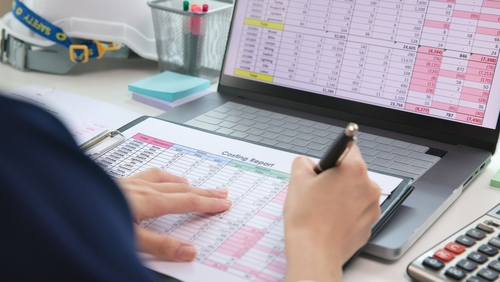 mulher analisa custos fixos e variáveis de uma planilha impressa