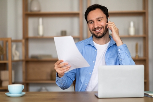 homem atende telefone em casa enquanto realiza trabalho intermitente