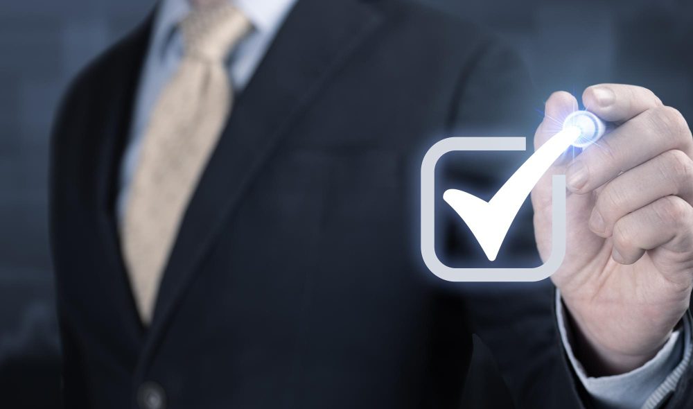 homem de paletó dá um check na tela simbolizando certificado de qualidade